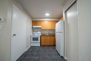 Kitchener apartment for rent - A kitchen with a white refrigerator, white oven, and white microwave.