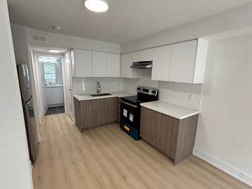 Kitchener apartment for rent - A kitchen with white cabinets and a wooden floor.