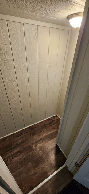 Clinton house for rent - a hallway with wood floors and white walls and a white door