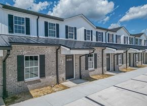 Manchester apartment for rent - a brick building with green shutters and a sidewalk