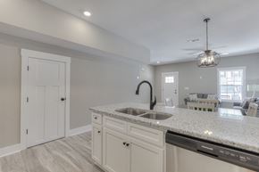 Manchester apartment for rent - the kitchen and living room in a new home with white cabinets