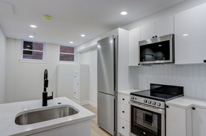 Boston apartment for rent - a kitchen with white cabinets and stainless steel appliances