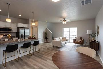 Waukee apartment for rent - A modern kitchen with a bar area and a living room with a couch and chairs.