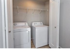 Waukee apartment for rent - A small laundry room with a washer and dryer.