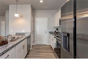 Waukee apartment for rent - A modern kitchen with a stainless steel refrigerator and wooden flooring.
