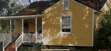 Mobile house for rent - A yellow house with a white porch.