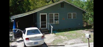 Mobile house for rent - a white car parked in front of a blue house