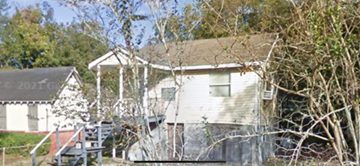 Mobile house for rent - A house with a porch and a tree in front.