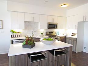 Los Angeles apartment for rent - A modern kitchen with a white countertop and wooden cabinets.