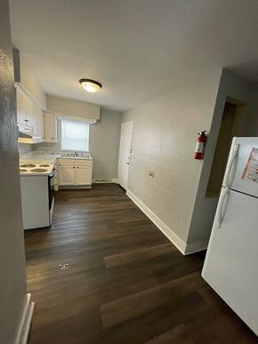 Lima apartment for rent - A kitchen with white appliances and wooden floors.