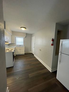 Lima apartment for rent - A kitchen with white appliances and wooden floors.