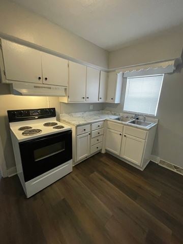 Lima apartment for rent - A kitchen with a black stove top oven and white cabinets.