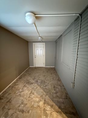 Tulsa house for rent - A hallway with a tiled floor and a white door.