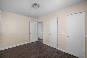 Saint Louis house for rent - a bedroom with white walls and doors and a wood floor