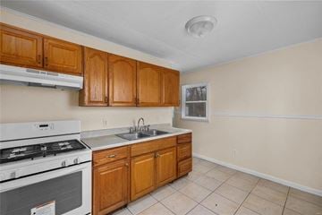 Saint Louis house for rent - a kitchen with wooden cabinets and a stove and a sink
