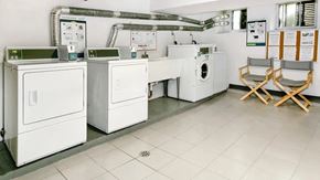 Toronto apartment for rent - a laundry room with four washing machines and folding chairs