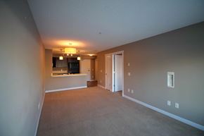 Edmonton house for rent - an empty living room and kitchen with a door to the bathroom