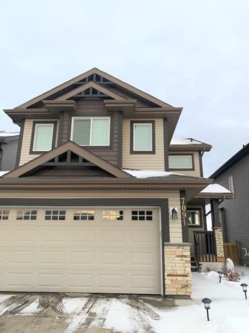Edmonton house for rent - a house with a garage door in the snow