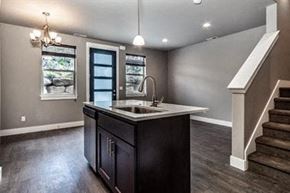Bend apartment for rent - A kitchen with dark wood floors and a white countertop.