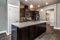 Bend apartment for rent - A kitchen with dark wood cabinets and a white counter.