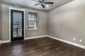 Bend apartment for rent - an empty living room with a ceiling fan and a door
