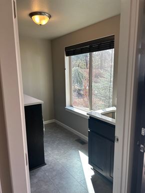 Bend house for rent - A kitchen with a black fridge and a window with blinds.