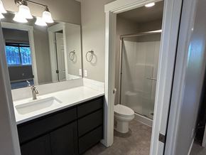 Bend house for rent - A bathroom with a sink, mirror, toilet and shower.