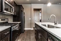 Bend apartment for rent - A kitchen with black cabinets and white countertops.