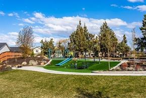 Bend apartment for rent - A playground with a green slide and a red brick building in the background.