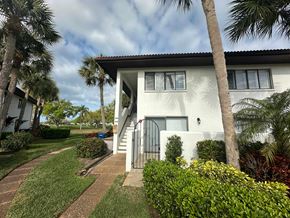 Bradenton house for rent - a white house with palm trees in front of it