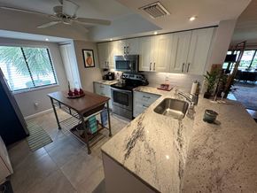 Bradenton house for rent - a kitchen with a granite counter top and a sink