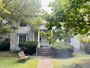 Louisville apartment for rent - a small white house with a yard and a bench