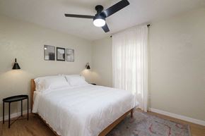 Gainesville apartment for rent - a bedroom with a white bed and a ceiling fan