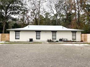 Gainesville apartment for rent - a white house with a tin roof and trees in the background