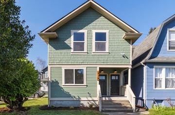 Tacoma apartment for rent - the front of a green house with a blue sky background