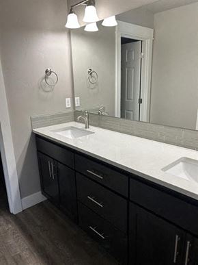 Bend apartment for rent - A bathroom with a white sink and black drawers.
