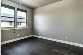 Bend apartment for rent - an empty bedroom with wood floors and two windows