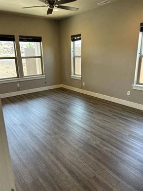 Bend apartment for rent - A room with a ceiling fan and wood flooring.
