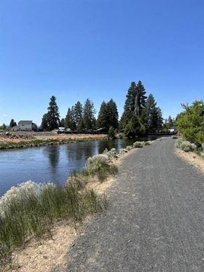 Bend apartment for rent - A path runs parallel to a body of water with trees in the background.