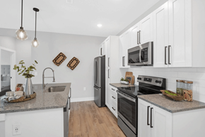 St. Louis apartment for rent - A kitchen with white cabinets and a granite countertop.
