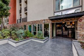 Studio City apartment for rent - A building with a stone wall and a glass door.