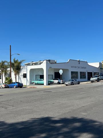 San Diego apartment for rent - A car dealership with a white building and cars parked outside.