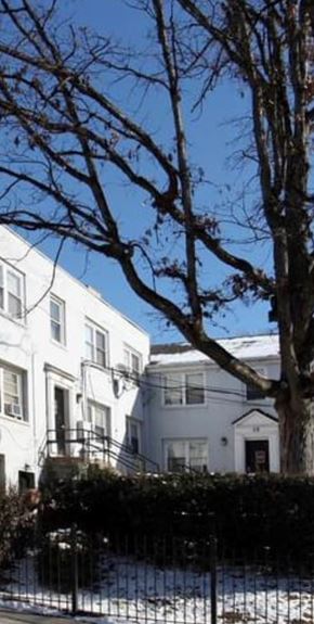 Washington apartment for rent - A white house with a black fence and a bare tree in front.