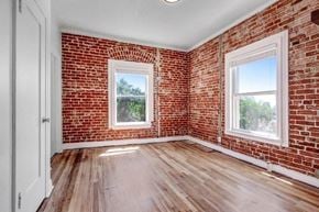 Los Angeles apartment for rent - an empty room with a brick wall and wooden floors
