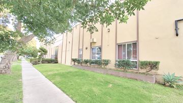 Anaheim apartment for rent - A building with a green lawn in front.