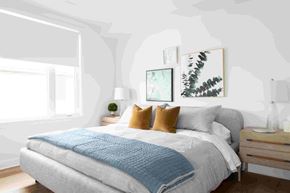 Ottawa apartment for rent - a bedroom with white walls and a bed with a blue blanket and pillows