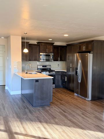 Bend apartment for rent - A modern kitchen with dark wood cabinets and stainless steel appliances.