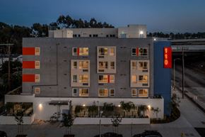 Los Angeles apartment for rent - A modern building with a blue and orange sign on the side.