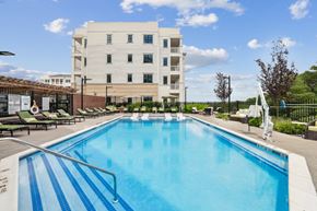 Hauppauge apartment for rent - A large swimming pool in front of a white building.