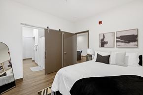 Neenah apartment for rent - A bedroom with a large bed and a mirror on the wall.